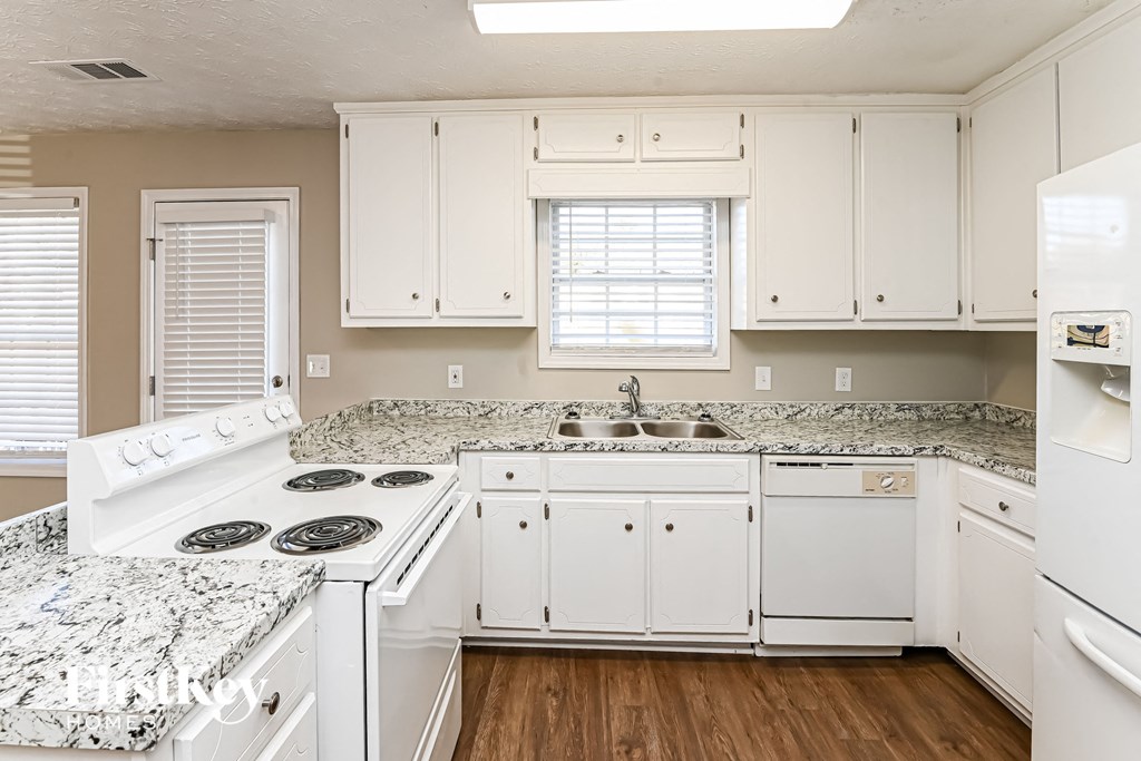 A kitchen with white appliances and cabinets.