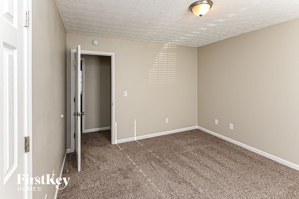 A room with a carpeted floor and a white door.