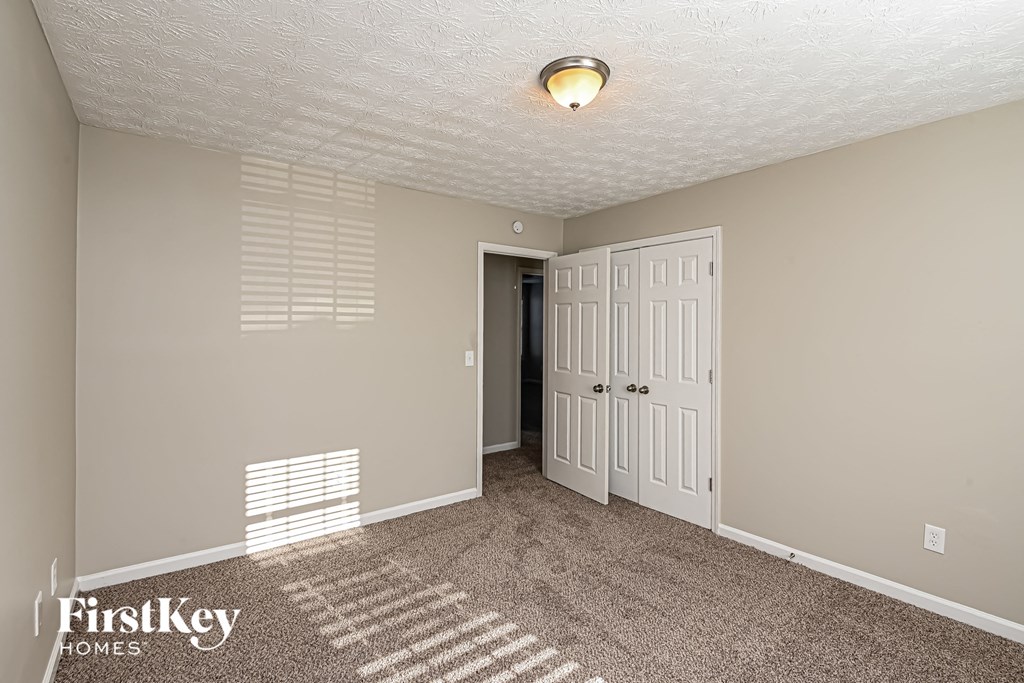 A room with a carpeted floor and a white door.