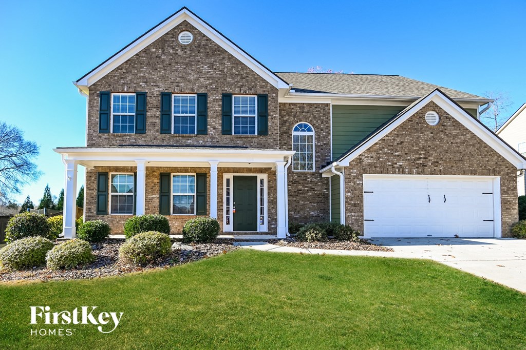 a home with a lawn and a white garage door