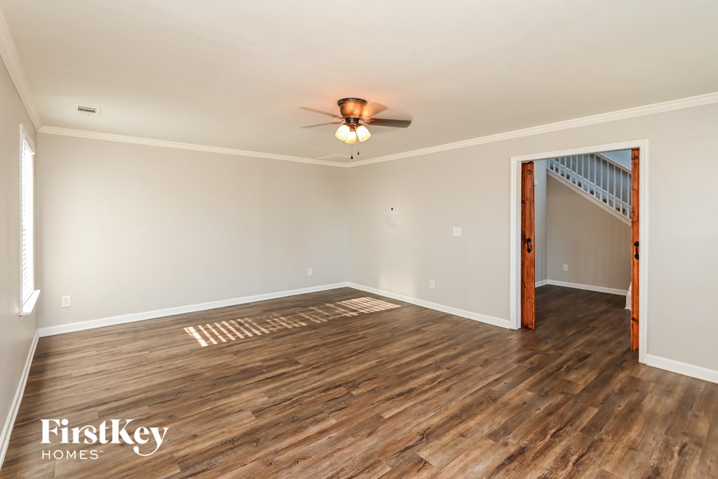 a living room with wood flooring and a ceiling fan