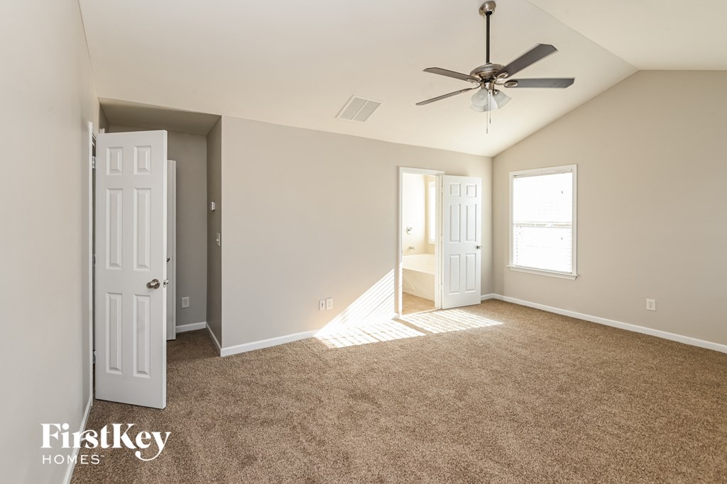 a living room with carpet and a ceiling fan