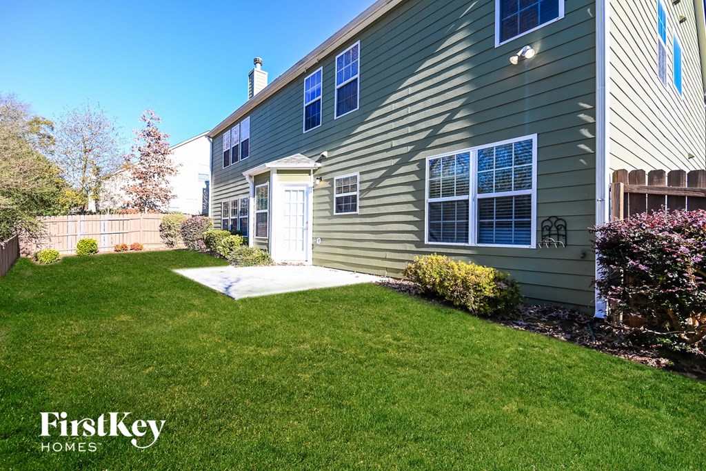a side view of a house with a yard and a sidewalk