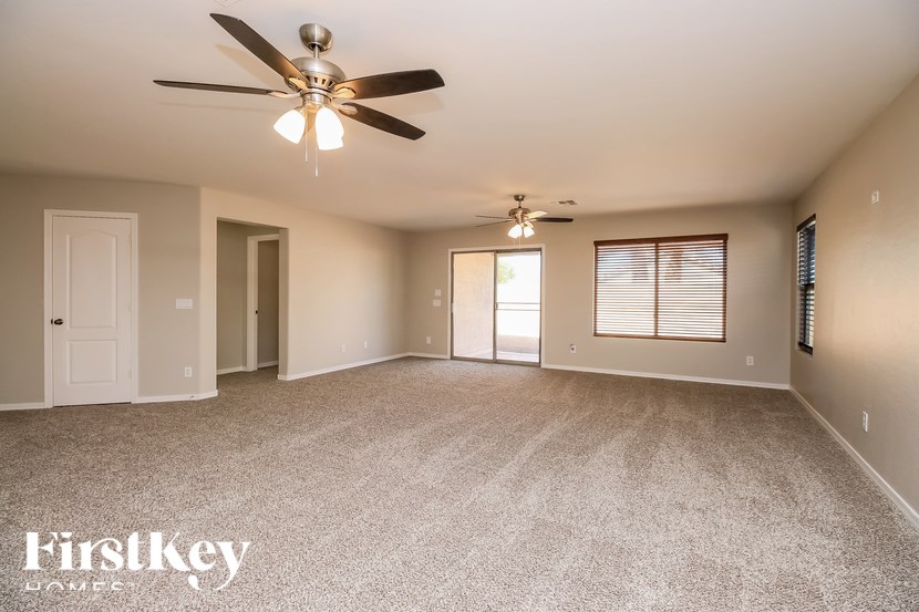 A spacious room with a ceiling fan and carpeted floor.