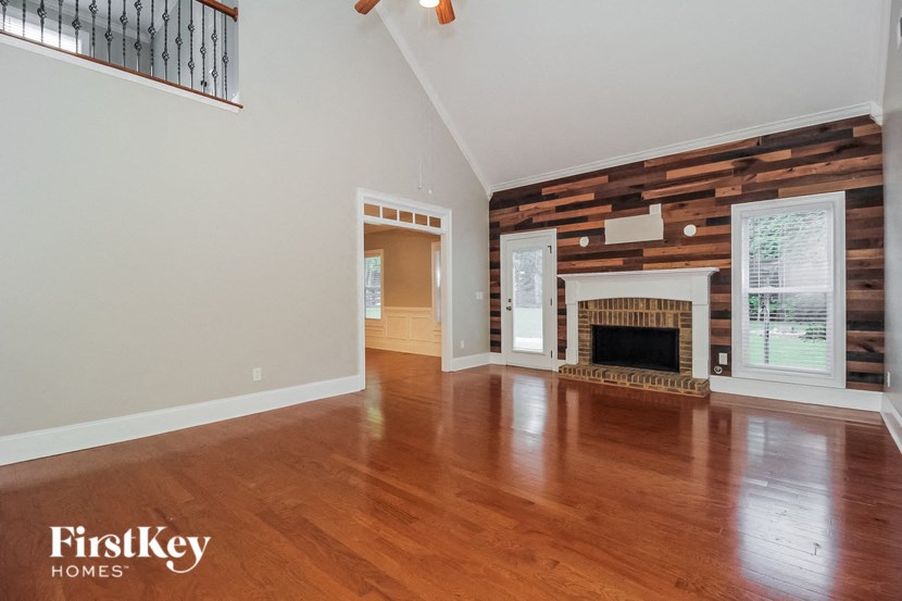 a living room with a fireplace and wooden floors