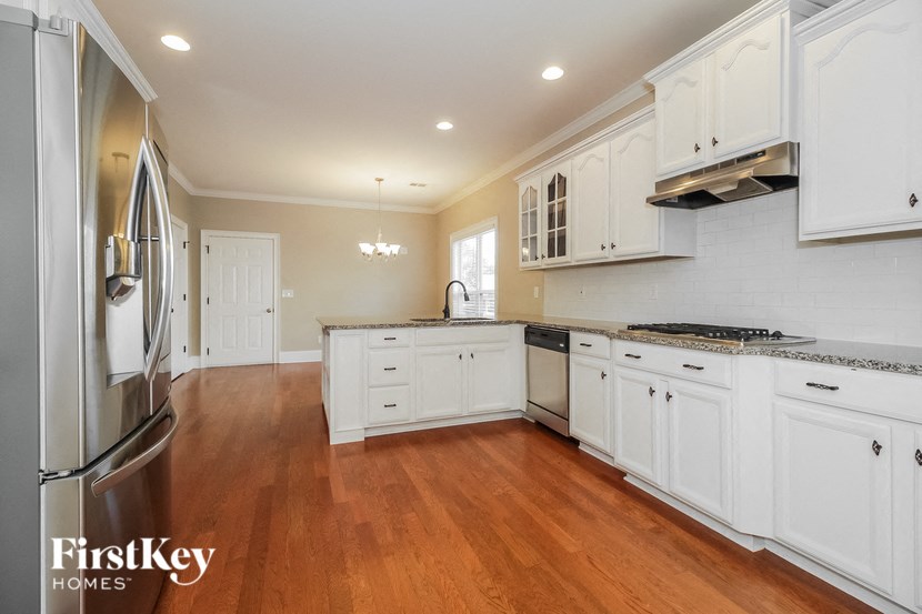 a kitchen with white cabinets and a wood floor