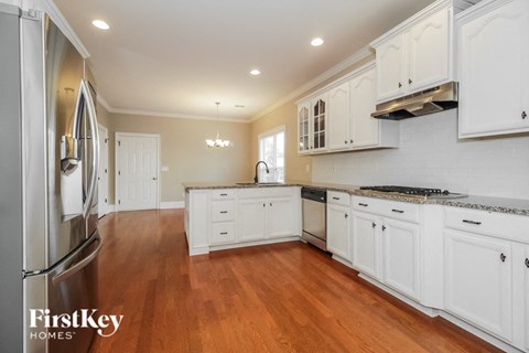 a kitchen with white cabinets and a wood floor