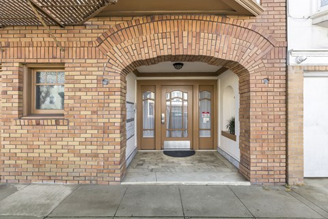 A brick building with a white door and a window above it.