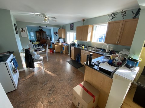 a cluttered kitchen with a box on the floor