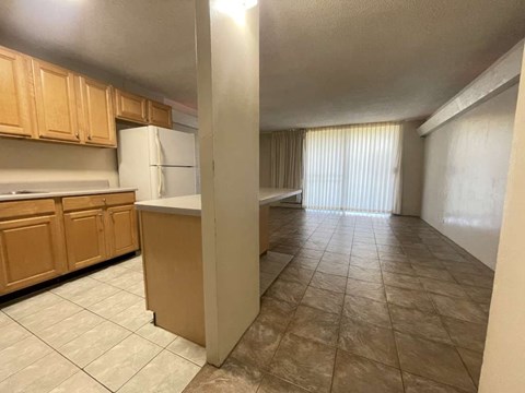 A kitchen with wooden cabinets and a white refrigerator.