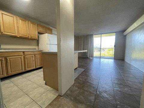 A kitchen with wooden cabinets and a tiled floor.