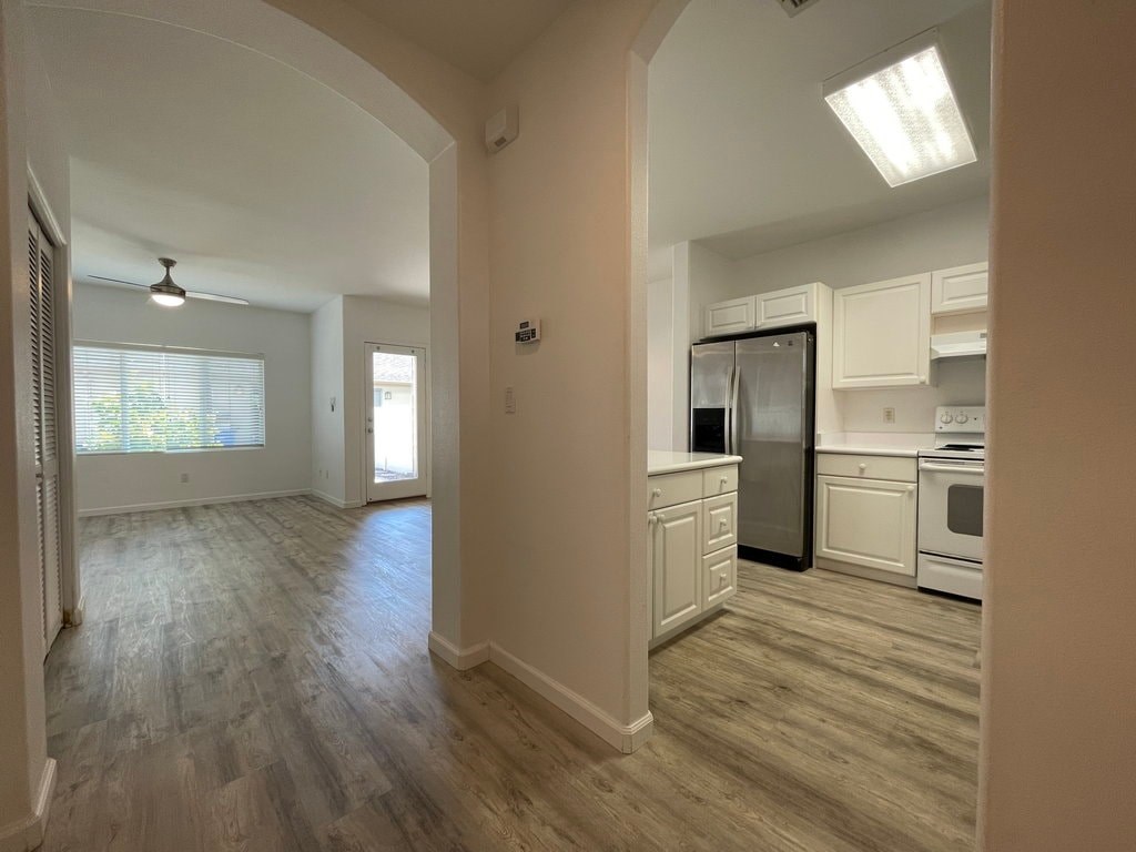 A kitchen with a refrigerator, oven, and cabinets.