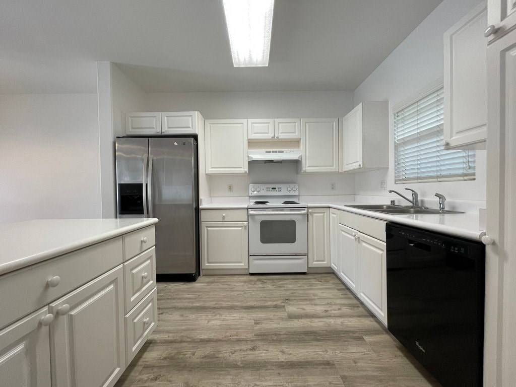 A kitchen with white cabinets and a black oven.