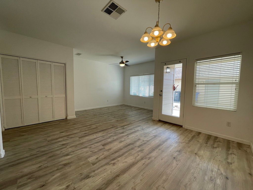 A room with wooden flooring and a ceiling fan.