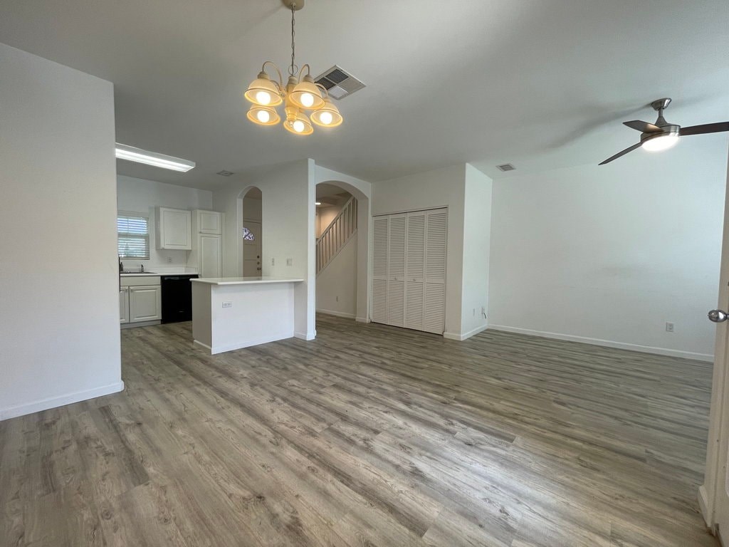 A room with a white kitchen island and wooden flooring.