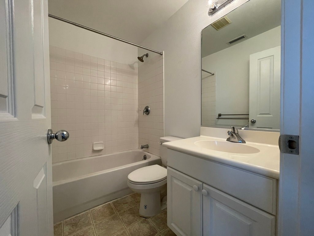 A white bathroom with a toilet, sink, and bathtub.