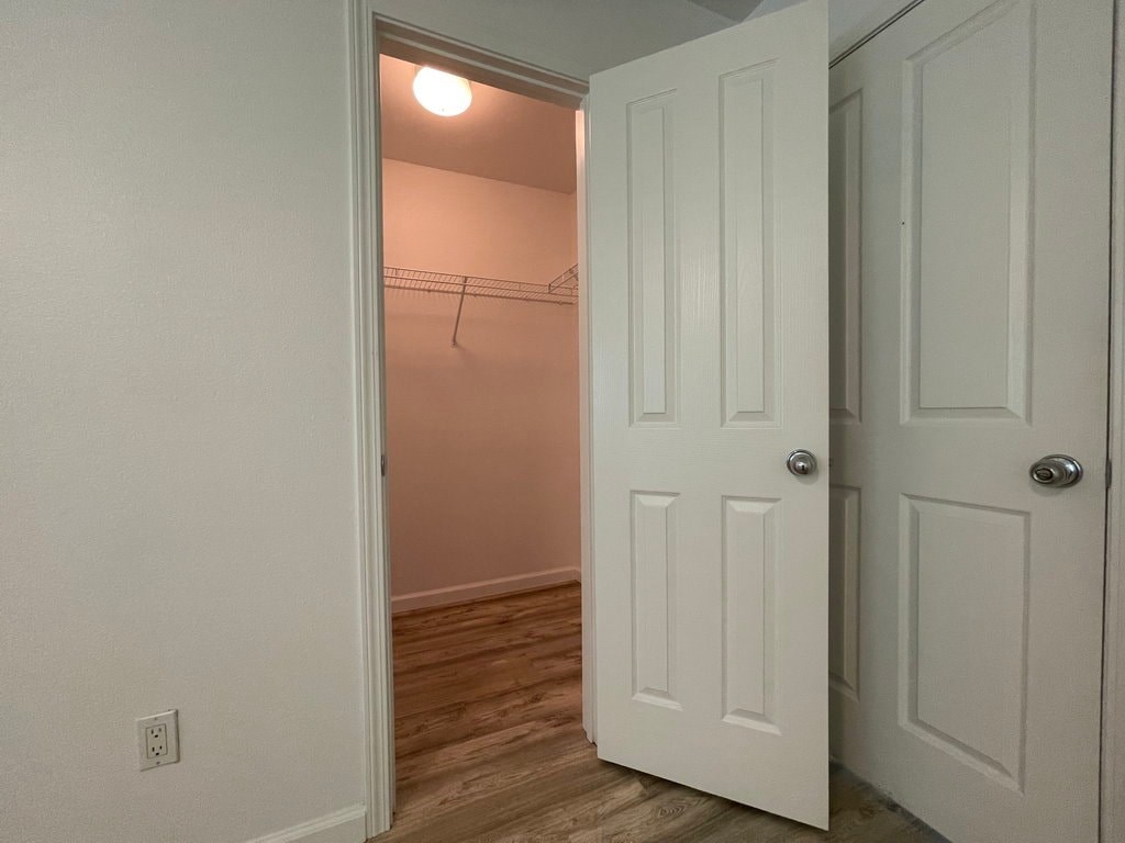 A white door is open to a room with a light on.