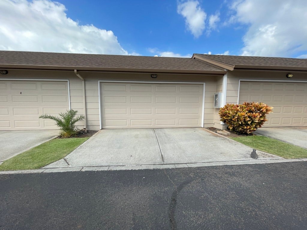 A house with a grey roof and two garages.