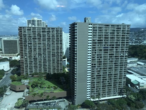 Two large buildings are surrounded by greenery.