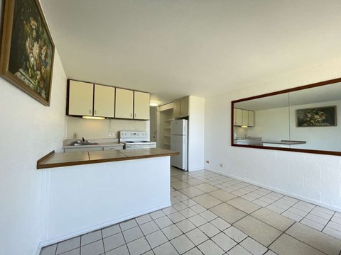 A kitchen with white cabinets and a tiled floor.