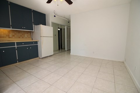 A kitchen with white cabinets and a white refrigerator.
