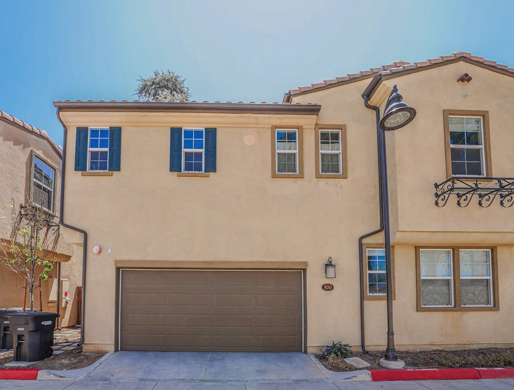 a beige house with a garage door and a street light