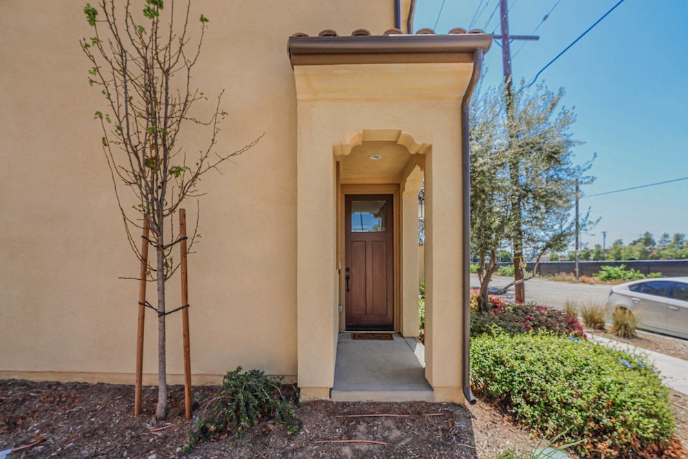 the entrance to a beige building with a brown door
