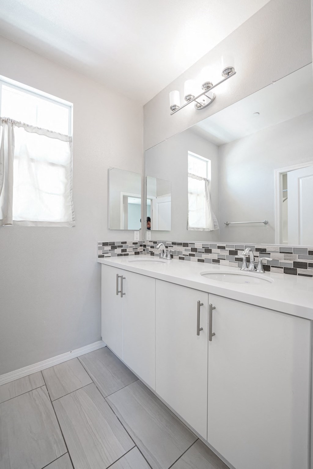 an empty bathroom with a sink and a mirror