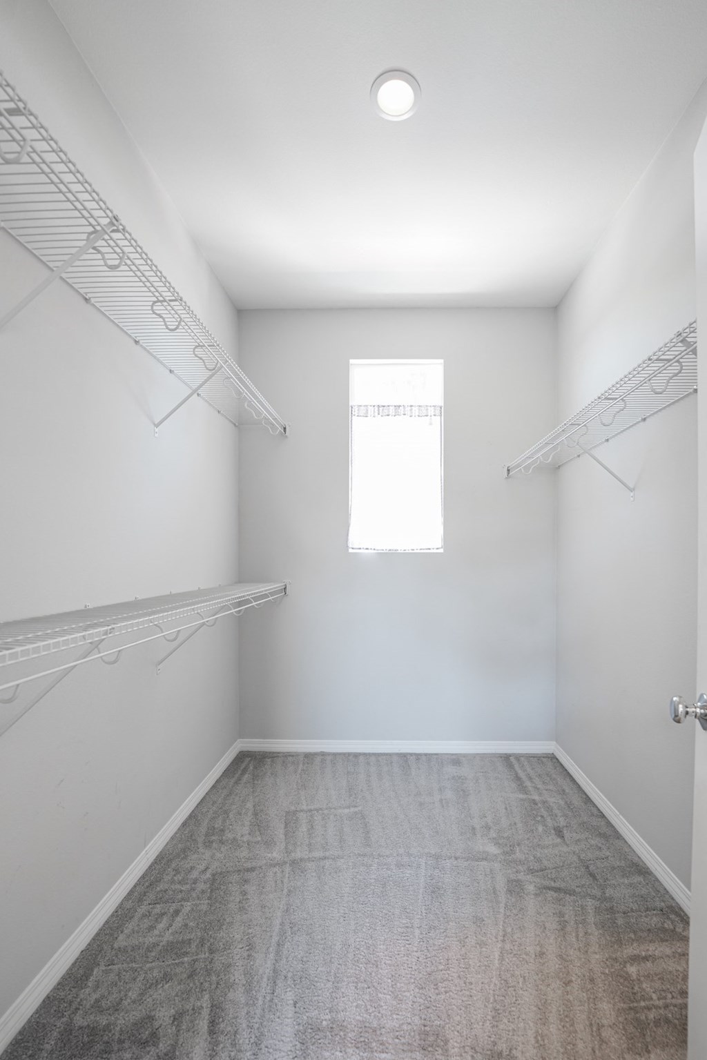 an empty room with white walls and a window