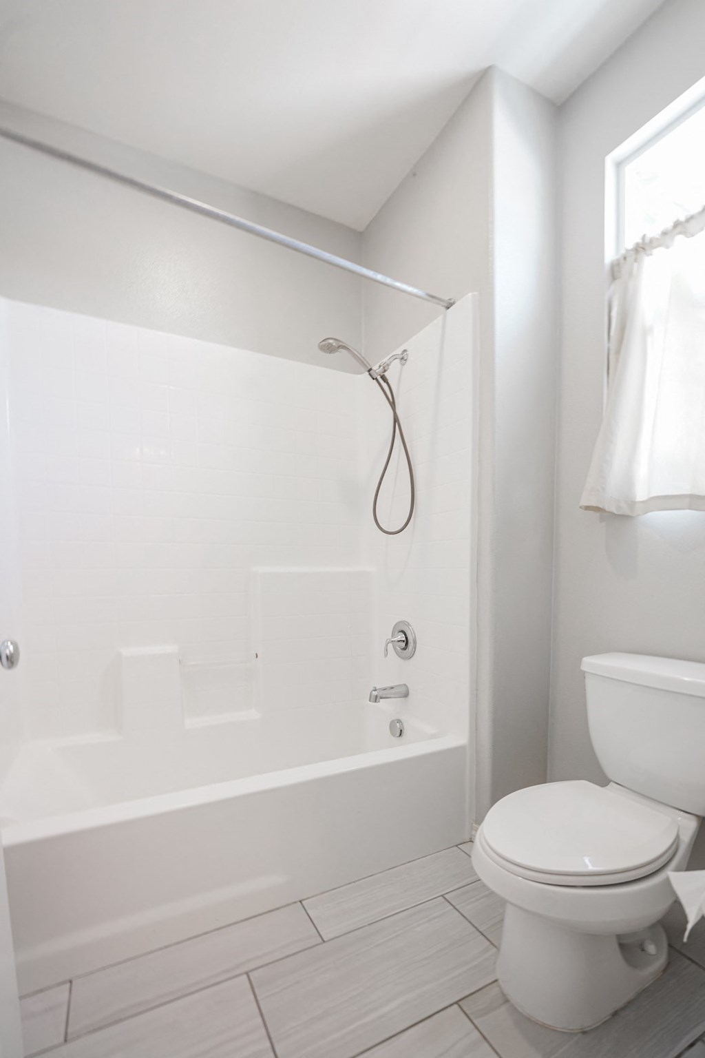 a white bathroom with a toilet and a tub