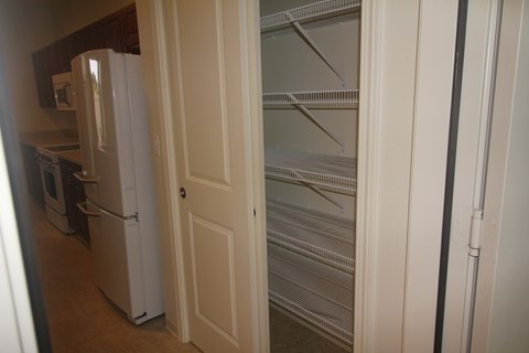 A white refrigerator is in a kitchen next to a white door.