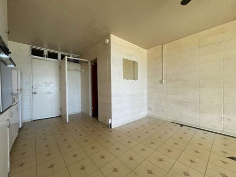 A kitchen area with white cabinets and a tiled floor.