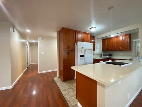 A kitchen with wooden cabinets and a white refrigerator.