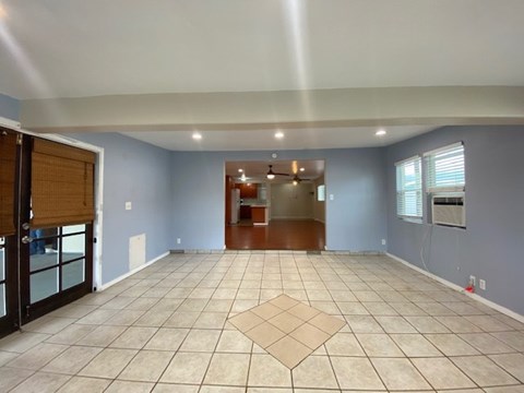 A spacious room with a tile floor and a ceiling fan.
