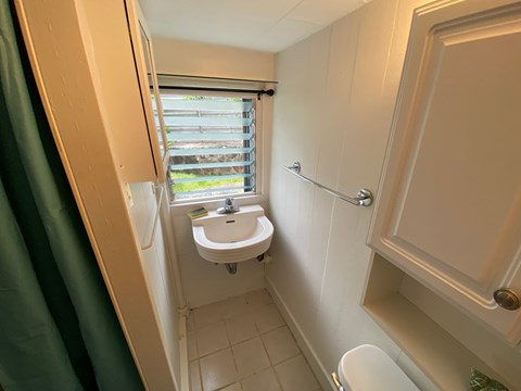 A small bathroom with a toilet, sink and window.