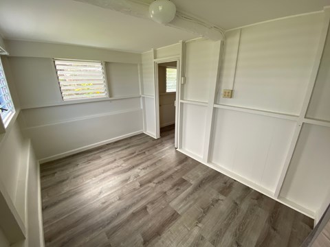 A room with wooden flooring and white walls.