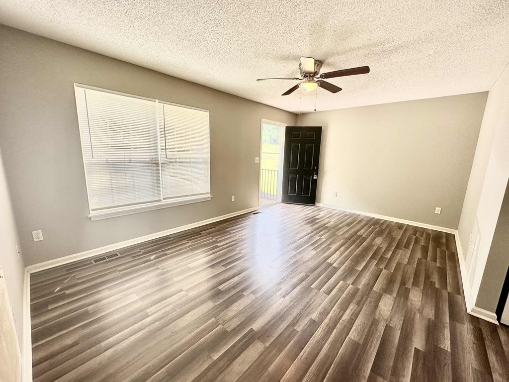 A room with wooden flooring and a ceiling fan.