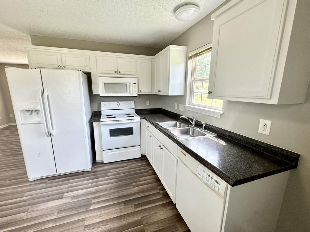 A kitchen with white appliances and cabinets.