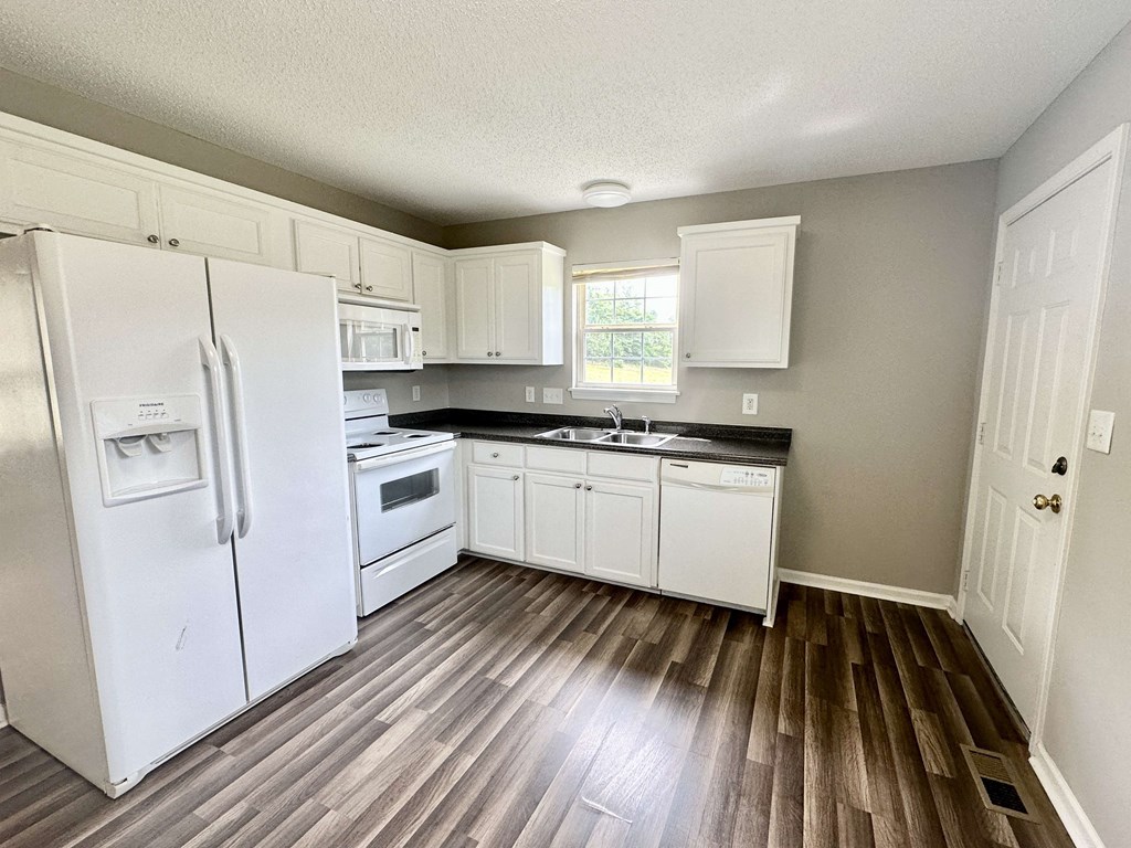 A kitchen with white appliances and cabinets.