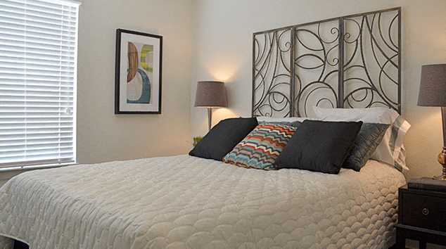 a bedroom with a large bed and a painting on the wall