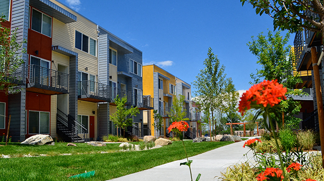a row of townhouses with a sidewalk in front of them