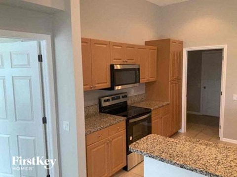 A kitchen with wooden cabinets and granite countertops.