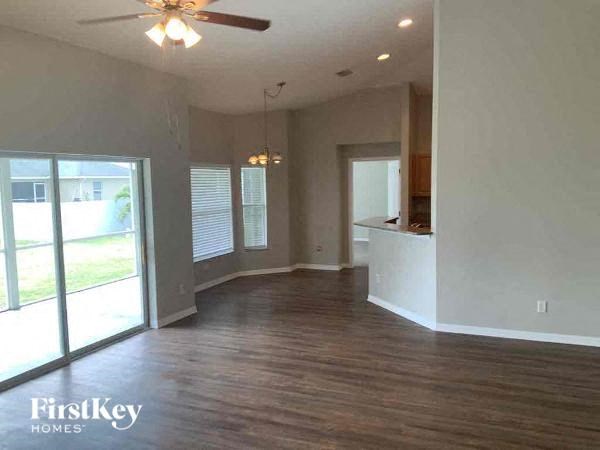 A spacious room with wood flooring and a ceiling fan.