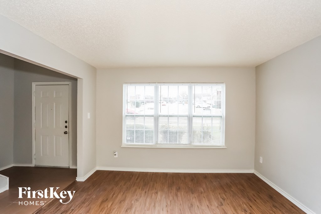 a living room with wood floors and a large window