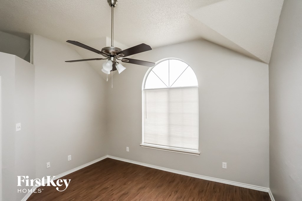 a bedroom with a ceiling fan and a large window