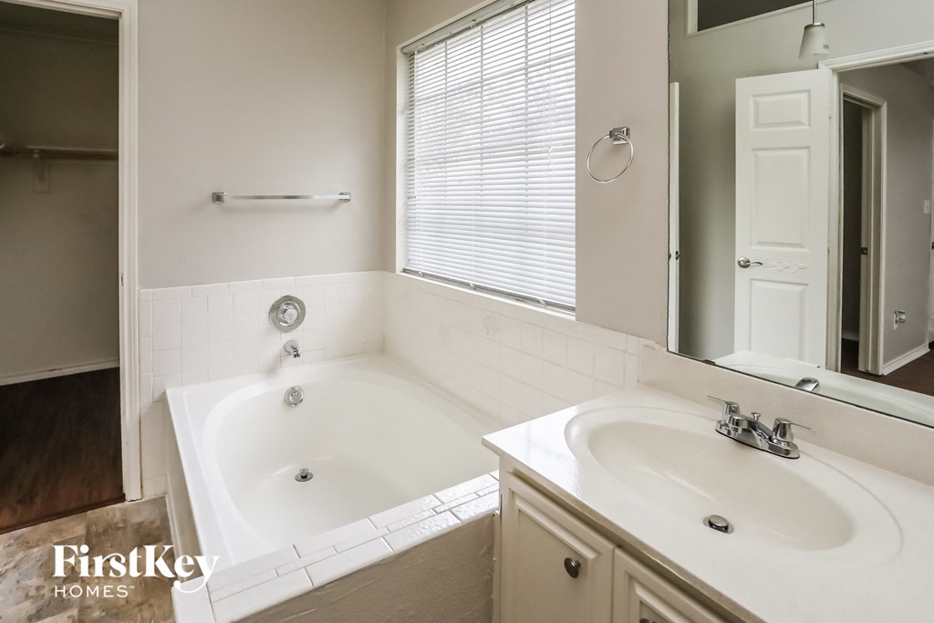 a bathroom with a tub and a sink and a mirror