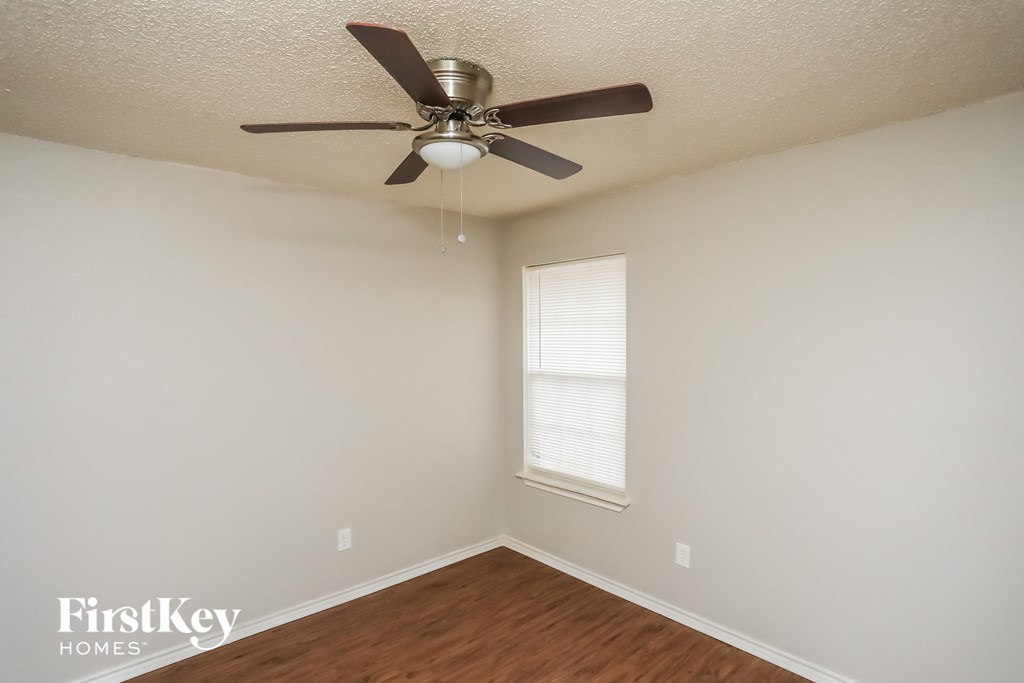 a bedroom with a ceiling fan and a window