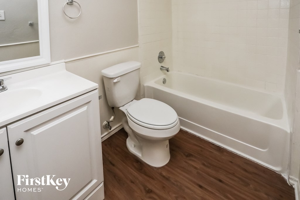 a bathroom with a toilet and a tub and a sink