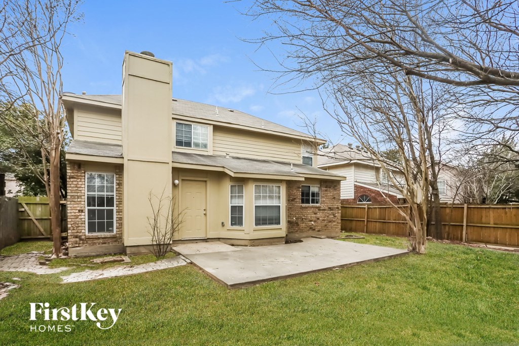 the front of a house with a yard and a concrete driveway