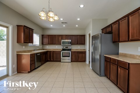 A kitchen with brown cabinets and a refrigerator.